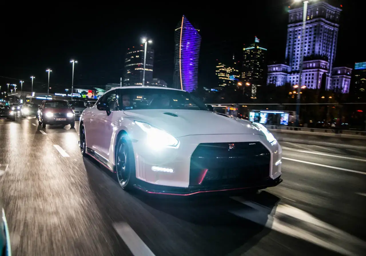 Biały Nissan GTR na nocnej ulicy Warszawy. Zastanawiasz się nad nissan gtr cena?