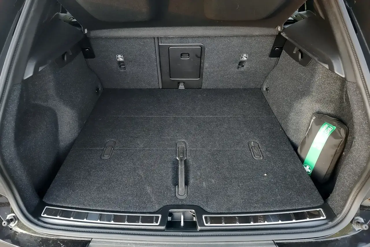 Pusty bagażnik Volvo EX40, gotowy na podróż. W rogu widoczna apteczka.