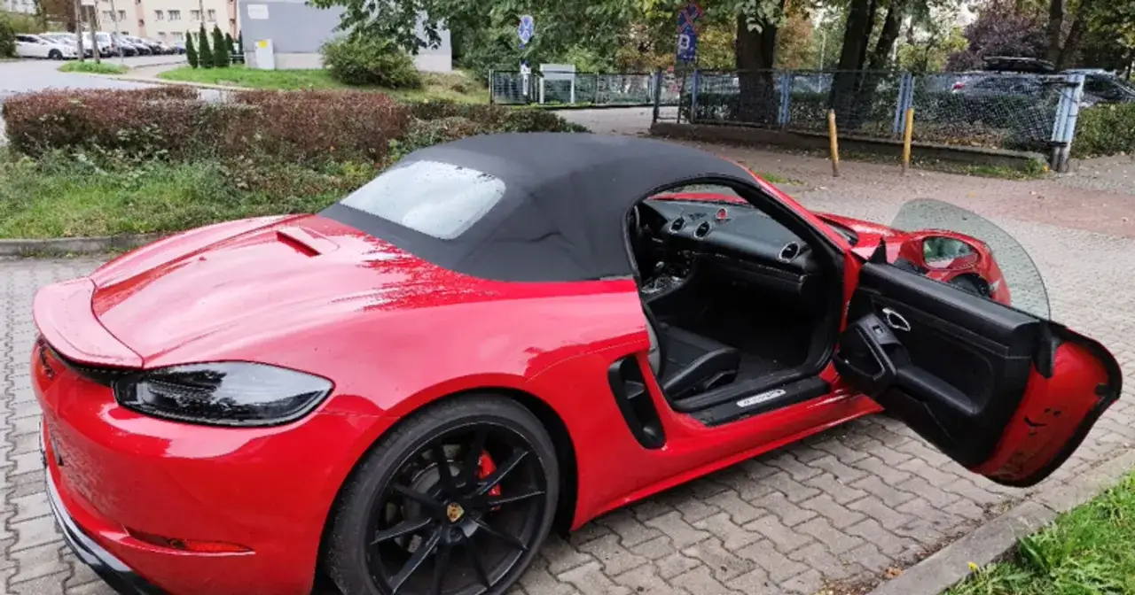 Czerwony kabriolet Porsche z otwartymi drzwiami. Wartość rynkowa samochodu, tabela, urząd skarbowy - wszystko to może być związane z jego wyceną.