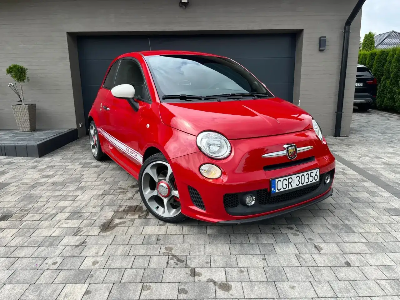 Czerwony Abarth 500 z białymi lusterkami i paskiem
