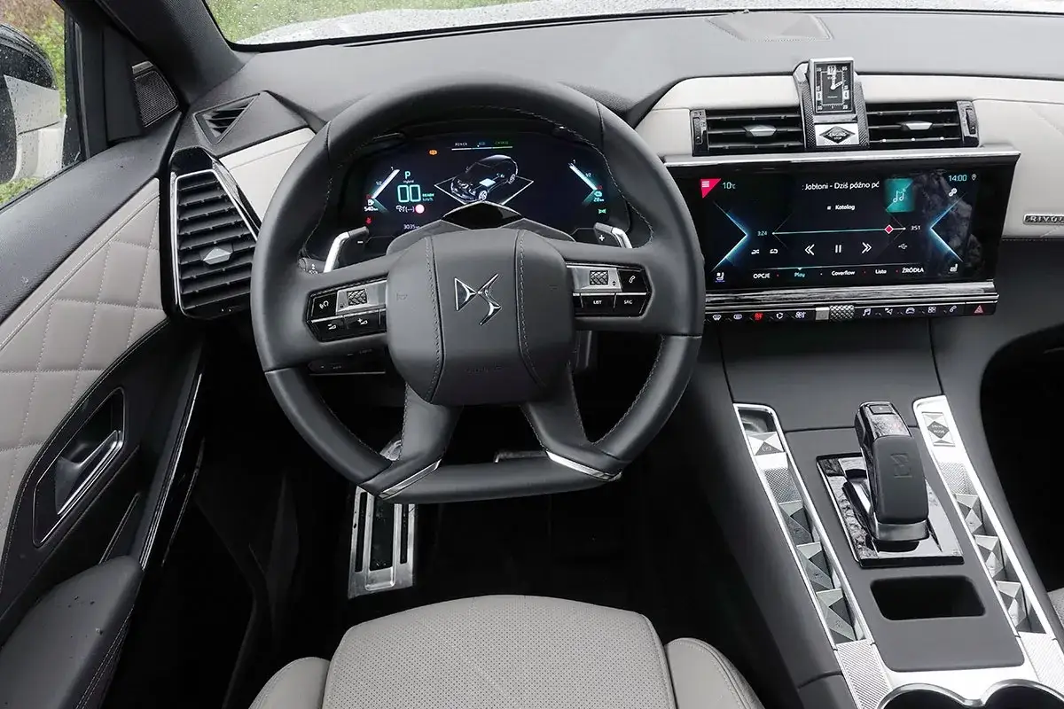 Wnętrze Citroëna DS7 z cyfrowym kokpitem i ekranem multimediów. Eleganckie przeszycia na drzwiach i fotelach dodają luksusu.