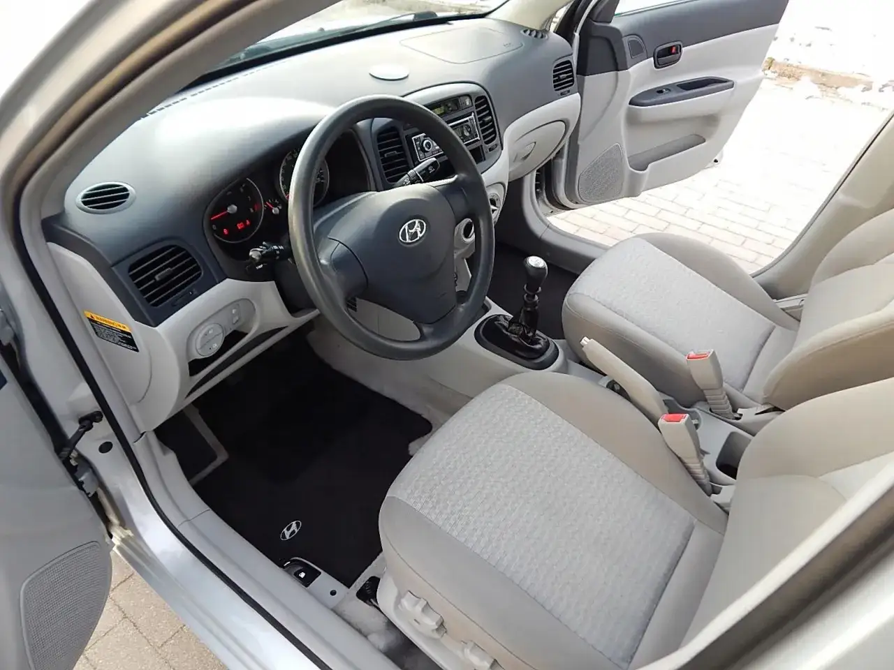 Wnętrze Hyundai Accent: kierownica, deska rozdzielcza, fotele i dźwignia zmiany biegów.