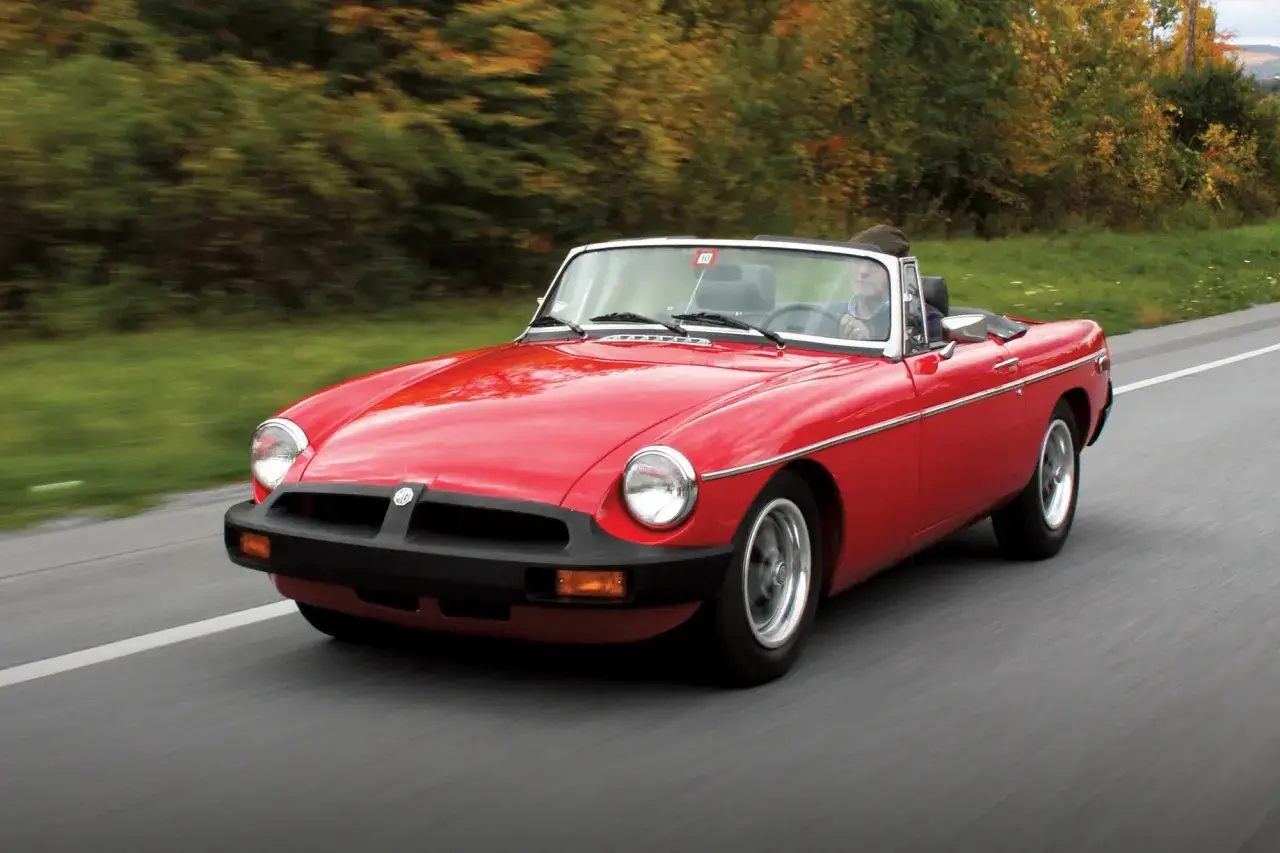 Czerwony kabriolet MG mknie po drodze. Klasyk, który wciąż budzi zachwyt. Mg co to za marka? To brytyjska legenda motoryzacji!