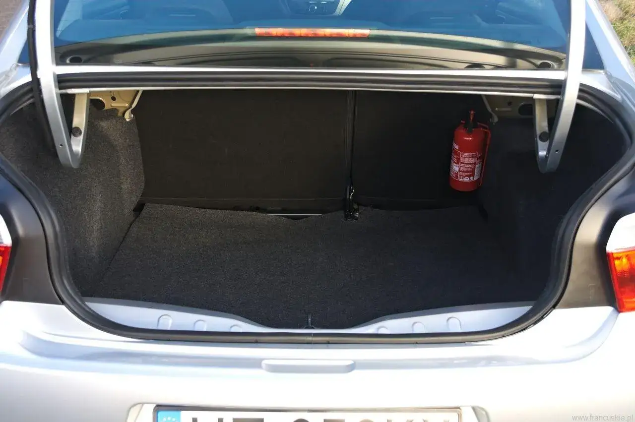 Bagażnik Citroen C Elysee, czysty i przestronny, z gaśnicą po prawej stronie. Gotowy na podróż.