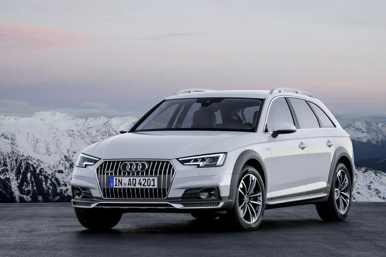 Biały Audi allroad gotowy na przygodę w górach.