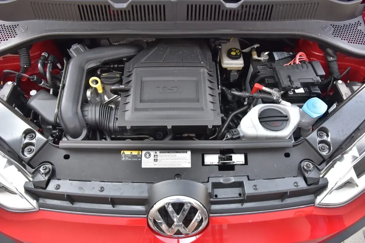 Silnik 1.0 TSI 110 KM w samochodzie Volkswagen. Widoczny jest blok silnika, akumulator i płyny eksploatacyjne.