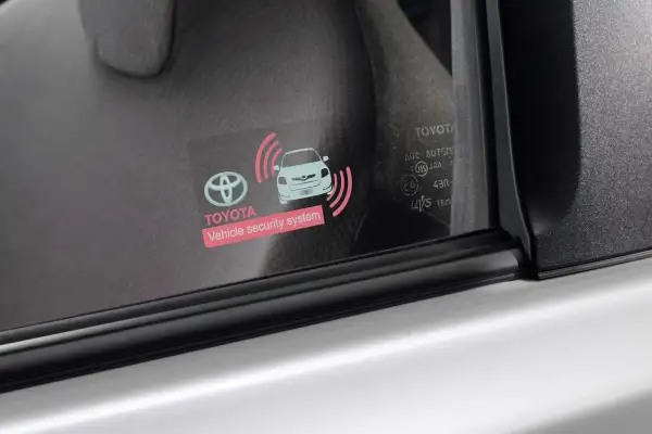 Naklejka na szybie Toyoty z symbolem samochodu i falami, informująca o systemie bezpieczeństwa. Działa dzięki bluetooth low energy, jak działa?